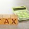 FP_IVA_wooden-cubes-with-word-tax-and-calculator-on-grey-background-scaled